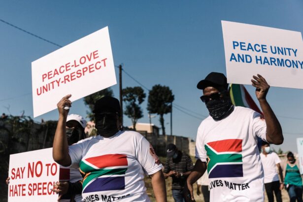 South Africans holding signs promoting peace, unity, and harmony amid growing immigration tensions.